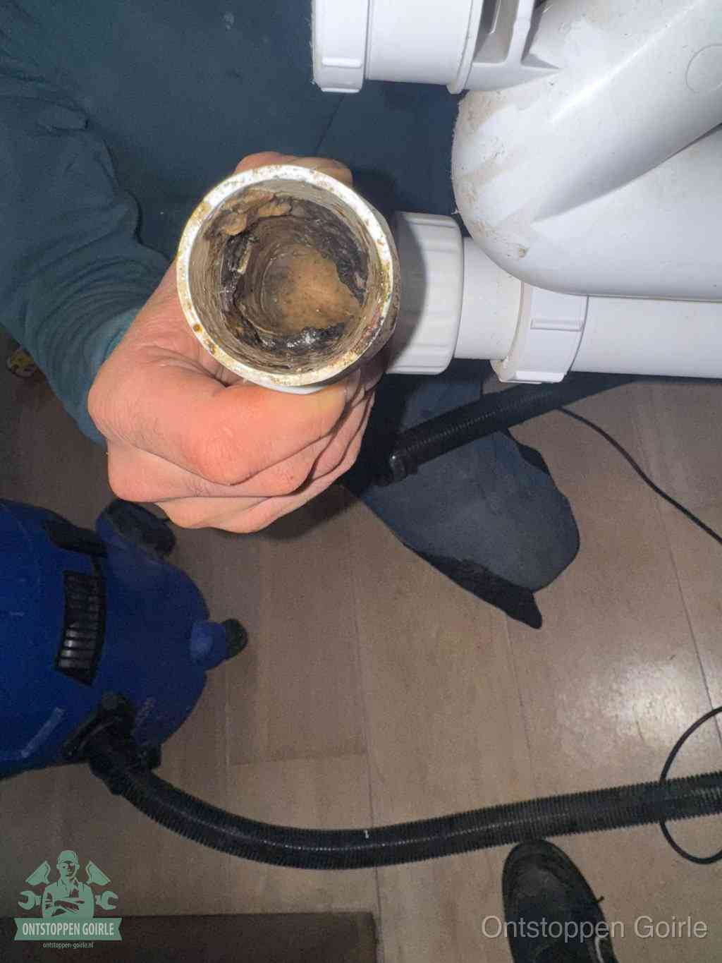 Een losgekoppeld afvoerbuisstuk dat van binnen volledig is dichtgeslibd, het gevolg van een verstopping te lang laten zitten in Goirle