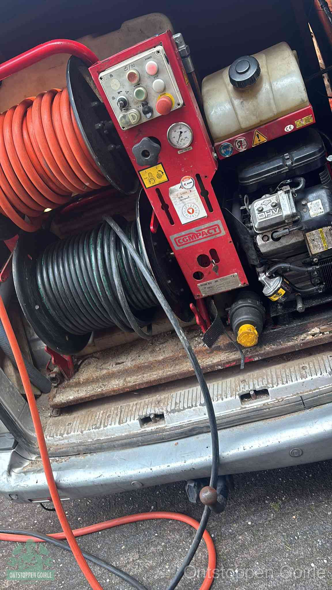Een rood hogedruk-rioolreinigingstoestel met slangen in de laadbak van de bedrijfsbus, apparatuur voor een hardnekkige wc-verstopping in Goirle