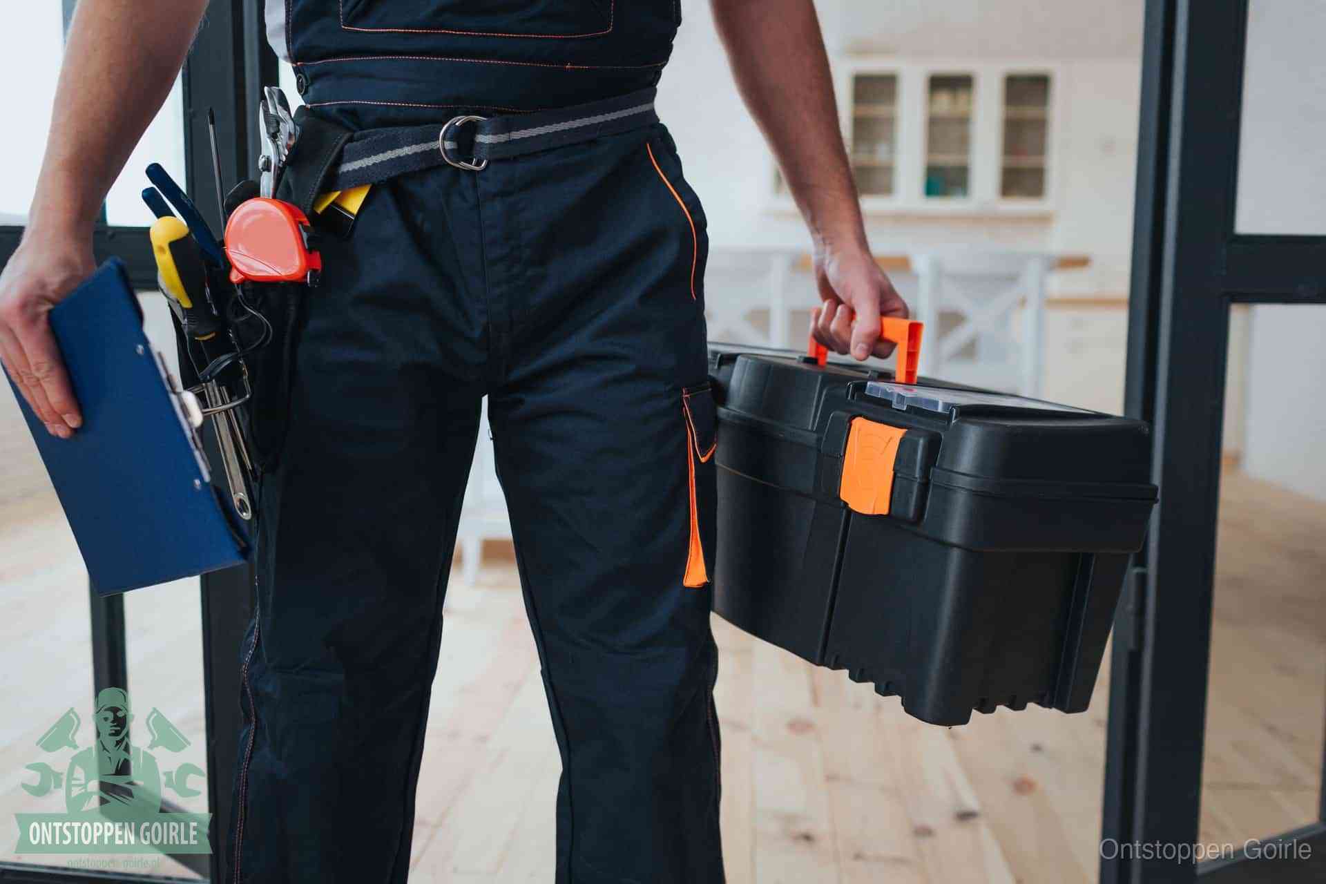 Een monteur met gereedschapsriem en klembord, klaar om een transparante prijs voor het wc ontstoppen in Goirle te geven