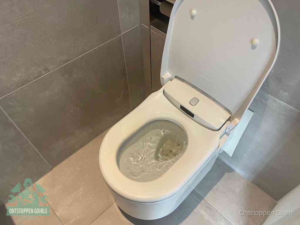 Een toiletpot vol troebel water met drijvend papier en restanten, de meest voorkomende oorzaak van een verstopte wc in Goirle
