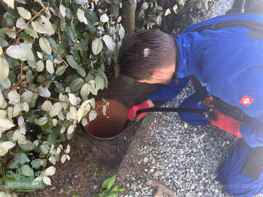 Monteur reinigt een rioolput met een slang, periodieke rioolreiniging in Goirle