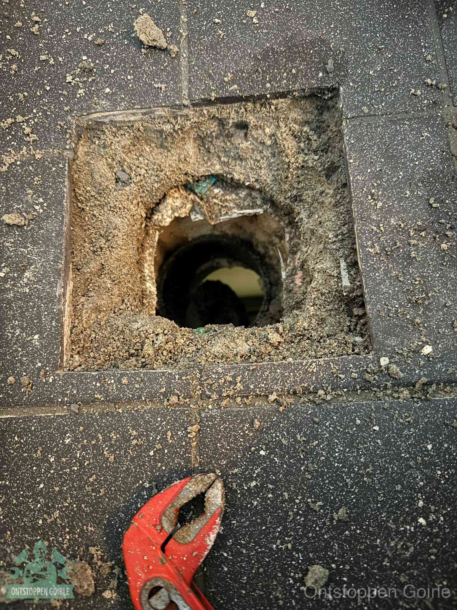 Geopend rioolputje op de erfgrens dat laat zien wie eigenaar is van de riolering in Goirle