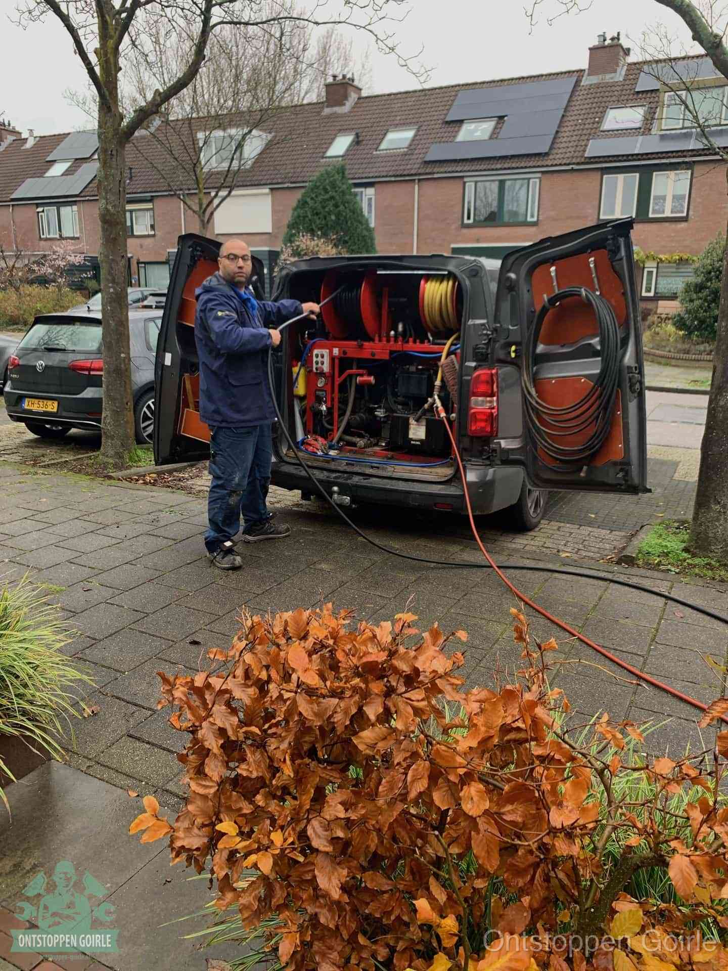 Monteur met rioolreinigingsbus levert rioolservice in de wijk in Goirle