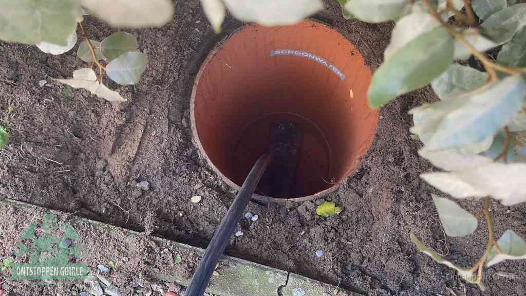 Open inspectieput in de tuin waar een veer rioolvliegjes en stankoverlast aanpakt in Goirle