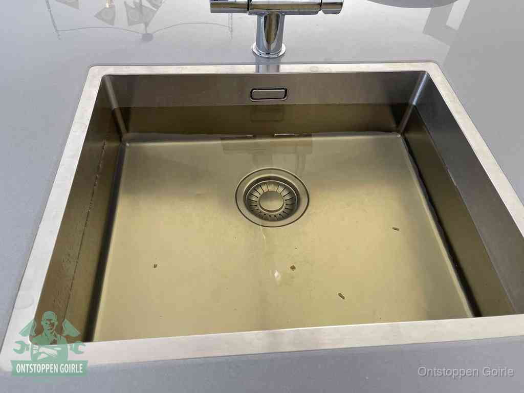 Stilstaand water in een rvs spoelbak dat niet wegloopt, een duidelijk signaal van een gootsteenverstopping in Goirle