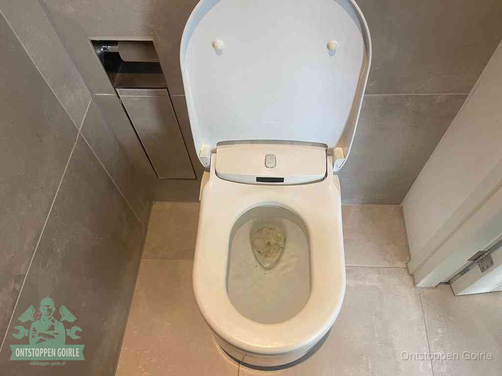 Een wit hangtoilet waarin een prop wc-papier op het water blijft drijven, een duidelijk signaal van een verstopte wc in Goirle