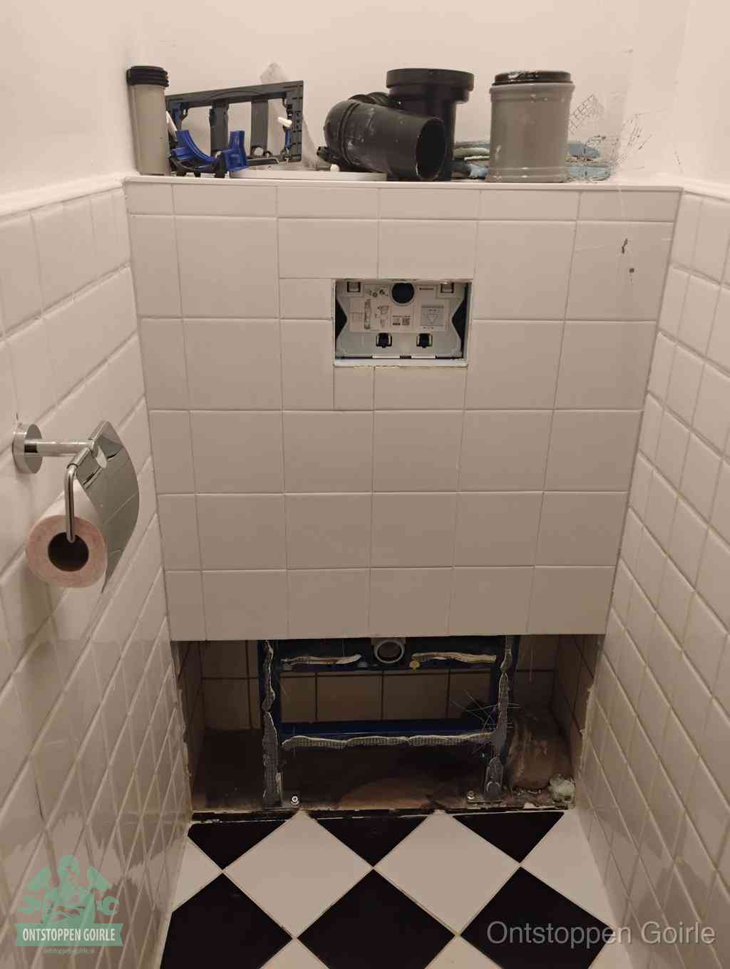Een toiletruimte waar het hangtoilet en de inbouwreservoir-onderdelen zijn vrijgelegd voor onderhoud, periodiek nazicht voorkomt een wc-verstopping in Goirle