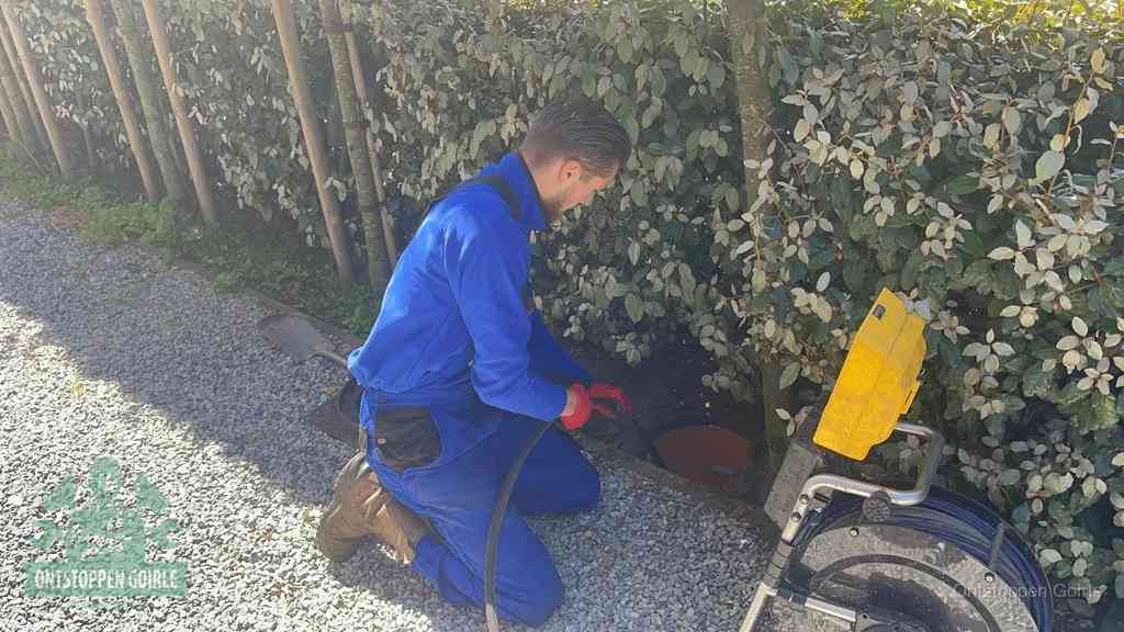 Monteur aan het werk bij een rioolput, de werkwijze voor riool ontstoppen in Goirle